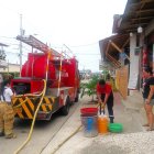 Personal del cuerpo de bomberos de Manglaralto colabora en el abastecimiento del líquido vital a los sectores donde el agua no llega