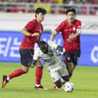 John Yeboah de Ecuador (C) cae ante la marca de Kim Bong-soo (d) y Kim Tae-hyeon de Corea del Sur el jueves pasado.