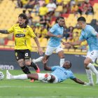 Darío Benedetto (i) es arrinconado por jugadores de la Católica.