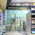 Una niña cacheando a un policía en una tienda de bebidas.