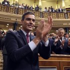 El socialista Pedro Sánchez aplaude después de ganar una votación parlamentaria en España.