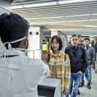 Un hombre usa una cámara termográfica para controlar la cabeza de las personas en el Aeropuerto Internacional Netaji Subhash Chandra Bose en Kolkata, siguiendo las recomendaciones del Ministerio de salud.