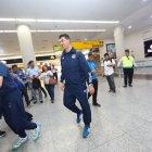 Los jugadores y el técnico Rescalvo (d) compartieron con los hinchas que fueron a recibirlos al aeropuerto.