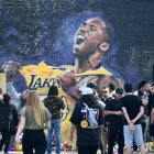 Fanáticos de Kobe Bryant cerca a una imagen de su ídolo, fallecido en un accidente aéreo.