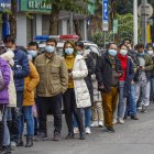 NANNING. Habitantes de esta ciudad china, hace fila al pie de una farmacia, en busca de mascarillas que ha vuelto un producto escaso y caro.