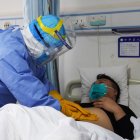 This photo taken on January 28, 2020 shows a medical staff member checking a patient infected by the novel coronavirus inside an isolation ward at a hospital in Zouping in China"s easter Shandong province. - China faced deepening isolation over its coronavirus epidemic on February 1 as the death toll soared to 259, with the United States leading a growing list of nations to impose extraordinary Chinese travel bans. (Photo by STR / AFP) / China OUT