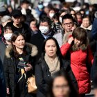 People wear surgical masks in fear of the coronavirus in Flushing, a neighborhood in the New York City borough of Queens on February 3, 2020. - China"s top leadership on Monday admitted "shortcomings and difficulties" in its response to the coronavirus outbreak and the government said it "urgently" needed medical supplies to battle the outbreak which has killed more than 360 people.The virus has since spread to more than 20 countries despite many governments imposing unprecedented travel bans on arrivals coming from China. (Photo by Johannes EISELE / AFP)
