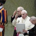 Pope Francis (C), flanked by Monsignor Leonardo Sapienza (Rear C) and Argentine priest, Monsignor Luis Maria Rodrigo Ewart (R), crosses himself during the weekly general audience on February 12, 2020 at Paul-VI hall in the Vatican. (Photo by Filippo MONTEFORTE / AFP)