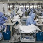 (FILES) This file photo taken on February 8, 2020 shows workers producing protective clothing at a factory which previously produced suits and sportswear and switched production for the fight against the deadly COVID-19 coronavirus, in Wuxi in China"s eastern Jiangsu province. - A diaper manufacturer in eastern China was closed for the Lunar New Year holiday when it heard from officials that China needed vast amounts of masks to fight the virus epidemic and factories needed to chip in, and in just over two days converted a manufacturing line in Fujian province to make face masks. (Photo by STR / AFP) / China OUT / TO GO WITH China-health-virus-manufacturing,FOCUS by Beiyi SEOW