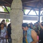 Una turista muestra su fe al tótem pidiendo un embarazo.