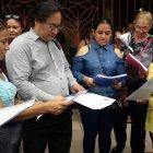 Padres de familias  muestran las hojas de los aciertos que tuvieron sus hijos en la primera prueba.