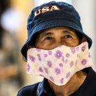 A shopper, wearing a protective facemask amid fears over the spread of the COVID-19 coronavirus, walks in a store in Bangkok on February 17, 2020. (Photo by Mladen ANTONOV / AFP)