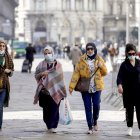 MILAN. Las pocas personas que se atreven a dejar sus casas, tomas medidas. Un grupo camina con mascarillas.