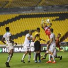 Esteban Dreer, golero de Liga de Portoviejo, intenta contener un balón en medio del acecho de los jugadores de Barcelona. Como fondo, las solitarias graderías del Monumental debido a la prohibición del ingreso de hinchas.