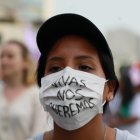 Una mujer usa un tapabocas que tiene escrito el mensaje "vivas nos queremos" durante una movilización este sábado con motivo de la celebración del Día Internacional de la Mujer, en Lima (Perú).