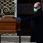 A man touches the coffin of his mother during a funeral service in the closed cemetery of Seriate, near Bergamo, Lombardy, on March 20, 2020 during the country"s lockdown aimed at stopping the spread of the COVID-19 (new coronavirus) pandemic. (Photo by Piero Cruciatti / AFP)