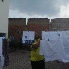 Chinto Espinoza colgando la ropa en el patio de su casa.