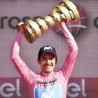 Richard Carapaz sostiene el trofeo del Giro de Italia logrado el año anterior.