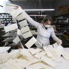 An employee controls surgical masks at a leather workshop turned into a mask factory, close to Vigevano, Lombardy, on March 19, 2020 during the country"s lockdown within the new coronavirus pandemic. - A crafts company specialized in the production of leather goods and accessories for the automotive and clothing sector, has now turned its activity to the production of surgical masks on behalf of a company from the nearby town of Galliate, in the wake of the needs following the coronavirus pandemic. (Photo by MIGUEL MEDINA / AFP)