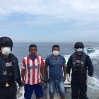 Dos de los pescadores rescatados con marinos de la Armada del Ecuador que los salvaron.