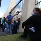 Personas usan mascarillas en el exterior de un cementerio de Guayaquil  a la espera de información de sus familiares fallecidos