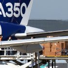 Trabajadores descargan del avión Airbus A350-1.000 máscaras faciales procedentes de China.