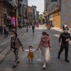 WUHAN. Una faamilia se arriesga a caminar por una de las calles de esta ciudad, tras más de dos meses de cuarentena. Llevan sus rostros protegidos.
