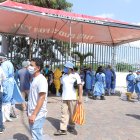 Ciudadanos en el exterior del hospital Guasmo Sur, uno de los centros de tratamiento del COVID-19, usan mascarillas como medida de prevención.
