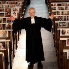 El pastor protestante Klaus-Martin Pothmann está de pie frente a fotos de creyentes de su parroquia que están pegadas a los bancos de la iglesia de San Pankratius en Hamm, Alemania.