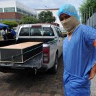 Un hombre se pone un traje protector fuera de la morgue del Hospital General Guasmo Sur para identificar a su pariente que murió del coronavirus.