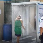 Dos personas se aprestan a pasar por el túnel de desinfección instalado en el mercado de Montebello, ubicado al norte de Guayaquil.