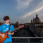 Jacopo Mastrangelo plays the guitar from his terrace overlooking Piazza Navona in Rome  on April 16, 2020, during a lockdown in Italy to curb the spread of the COVID-19 pandemic, caused by the new coronavirus. (Photo by Tiziana FABI / AFP)