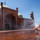 Municipal workers spray disinfectant at the main entrance of the Badshahi mosque ahead of the Muslim holy month of Ramadan during a government-imposed nationwide lockdown as a preventive measure against the COVID-19 coronavirus, in Lahore on April 22, 2020. -  (Photo by ARIF ALI / AFP)