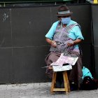 Una mujer con tapabocas vende lotería en las calles de Quito (Ecuador).
