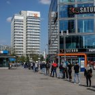 People wait in line to enter an electronics store at Berlin"s Alexanderplatz on April 27, 2020, amid the novel coronavirus COVID-19 pandemic. (Photo by David GANNON / AFP)
