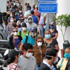 People wear face masks as they wait in line outside a bank in Guayaquil on April 28, 2020, amid the new coronavirus pandemic. - Ecuador reported 24,258 cases of COVID-19 so far, including 871 deaths, plus 1,212 other deaths of people who were suspectedly infected. (Photo by JOSE SANCHEZ LINDAO / AFP)