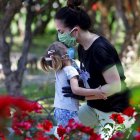Una mujer deja un beso en la frente de su hija en un parque en Córdoba, sur de España.