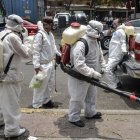 Cleaning workers wearing personal protective equipment (PPE) disinfect a street in Mexico City, on May 7, 2020, amid the new coronavirus pandemic. (Photo by PEDRO PARDO / AFP)