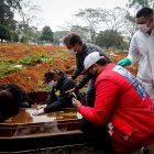 James Ala, coordinador de sepultureros, observa una familia desconsolada durante el entierro de un ser querido en el cementerio Vila Formosa, en Sao Paulo (Brasil).