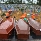 Los ataúdes se descargan para ser enterrados en una fosa común en el cementerio Nossa Senhora en Manaos, estado de Amazon, Brasil, el 6 de mayo de 2020. (Foto de MICHAEL DANTAS / AFP)