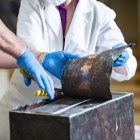 Ralph Coppage (izquierda), líder mecánico de mantenimiento, y Caitlin Smith (derecha), conservadora, trabajan para abrir la caja de recuerdos del Anfiteatro Memorial en la Capilla Inferior del Anfiteatro Memorial en el Cementerio Nacional de Arlington, Arlington, Virginia, Estados Unidos.