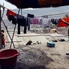 Protegidos con mascarillas, y en plena pandemia por coronavirus, habitantes del barrio pobre "Los Jazmines" extienden sus ropas recién lavadas, en el distrito de Comas, en Lima (Perú).