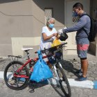 Enrique Bravo entrega el mandado a una de sus vecinas de la tercera edad, en Samanes. Él, para movilizarse, utiliza una bicicleta, así puede salir a ayudar todos los días.