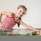 Niña realiza ejercicios e estiramientos.