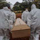 Employees carry the coffin of a person who died from COVID-19 at the Vila Formosa cemetery, in the outskirts of Sao Paulo, Brazil on May 20, 2020. - Brazil has emerged as the latest flashpoint in the coronavirus pandemic. The country has registered more than 270,000 cases and nearly 18,000 deaths so far, and the increase in infections is not expected to peak until June. (Photo by NELSON ALMEIDA / AFP)