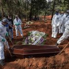 Employees bury the coffin of a person who died from COVID-19 at the Vila Formosa cemetery, in the outskirts of Sao Paulo, Brazil on May 20, 2020. - Brazil has emerged as the latest flashpoint in the coronavirus pandemic. The country has registered more than 270,000 cases and nearly 18,000 deaths so far, and the increase in infections is not expected to peak until June. (Photo by NELSON ALMEIDA / AFP)