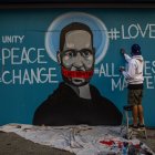 The artist Celos paints a mural in Downtown Los Angeles on May 30, 2020 in protest against the death of George Floyd, an unarmed black man who died while while being arrested and pinned to the ground by the knee of a Minneapolis police officer. - Clashes broke out and major cities imposed curfews as America began another night of unrest Saturday with angry demonstrators ignoring warnings from President Donald Trump that his government would stop violent protests over police brutality "cold." (Photo by Apu GOMES / AFP) / RESTRICTED TO EDITORIAL USE - MANDATORY MENTION OF THE ARTIST UPON PUBLICATION - TO ILLUSTRATE THE EVENT AS SPECIFIED IN THE CAPTION