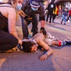 Manifestantes en Minneapolis asiste a una persona que cayó durante una protesta en la ciudad donde ocurrió el homicidio del ciudadano negro George Floyd en manos de un policía blanco.