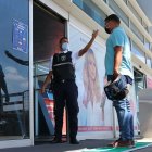 Un guardia de la Terminal Terrestre de Guayaquil toma la temperatura a un ciudadano.