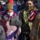 Personas que llevan máscaras faciales caminan por las calles de El Alto mientras Bolivia busca reactivar la economía en medio de la nueva pandemia de coronavirus.